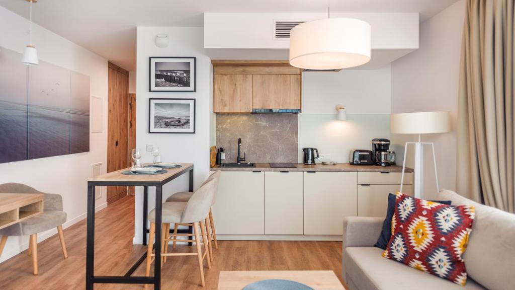 a living room and kitchen with a table and a couch at Jantaris B2 in Mielno