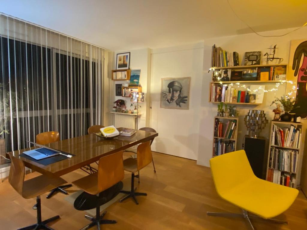 une salle à manger avec une table en bois et des chaises jaunes dans l'établissement Cosy et Arty, à Paris