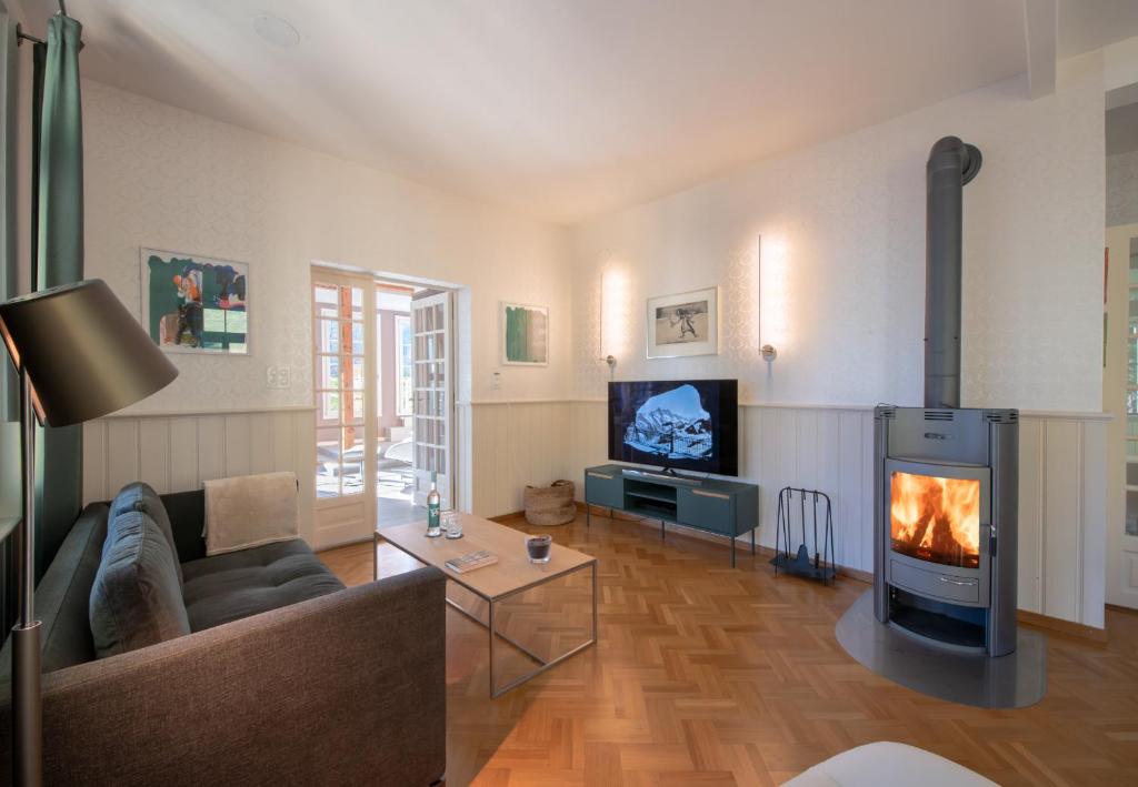a living room with a couch and a fireplace at Chalet Hunnenfluh Garden Apartment in Wengen
