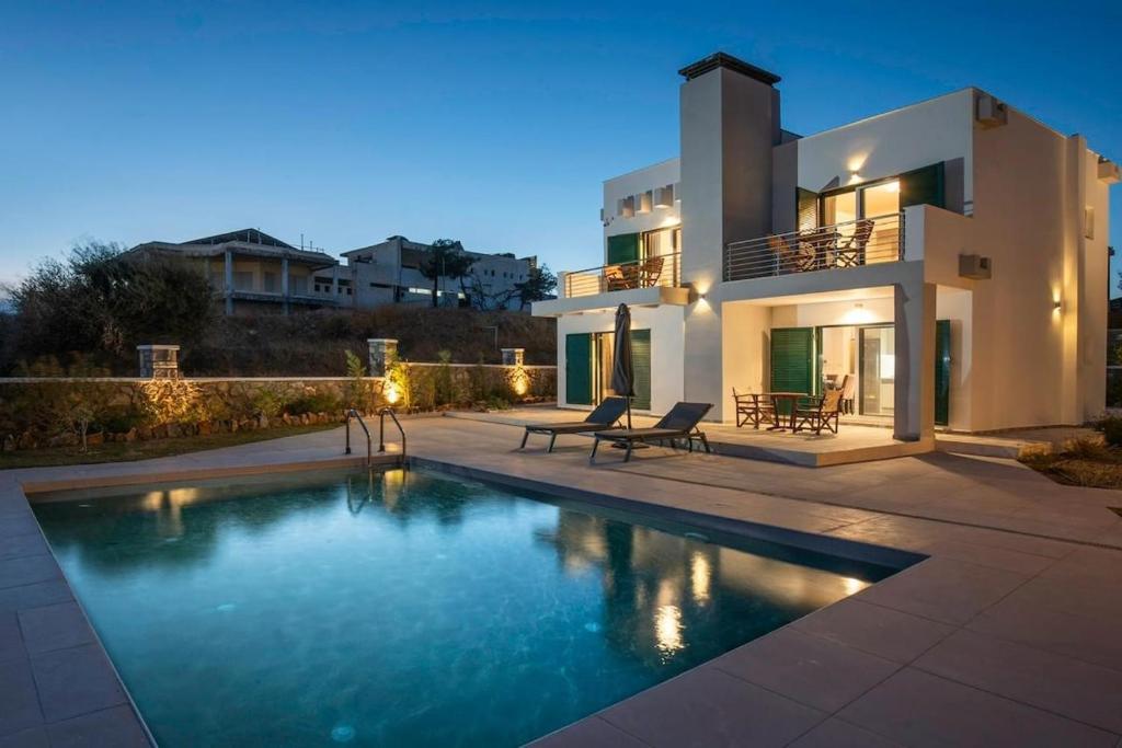a house with a swimming pool in front of it at Villa Kiki, Kiotari in Asklipiḯon
