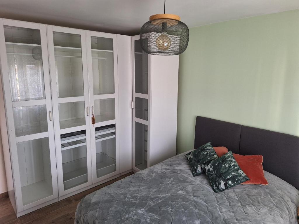 - une chambre avec un lit doté de portes en verre et d'une lampe dans l'établissement Parc de la roseraie, à Marseille