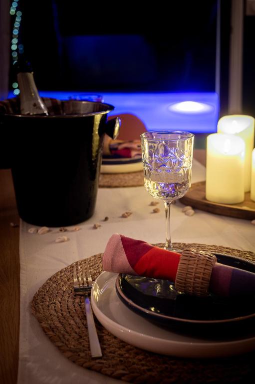 - une table avec une assiette et un verre de vin dans l'établissement Logement romantique avec jacuzzi privatif, à Biscarrosse