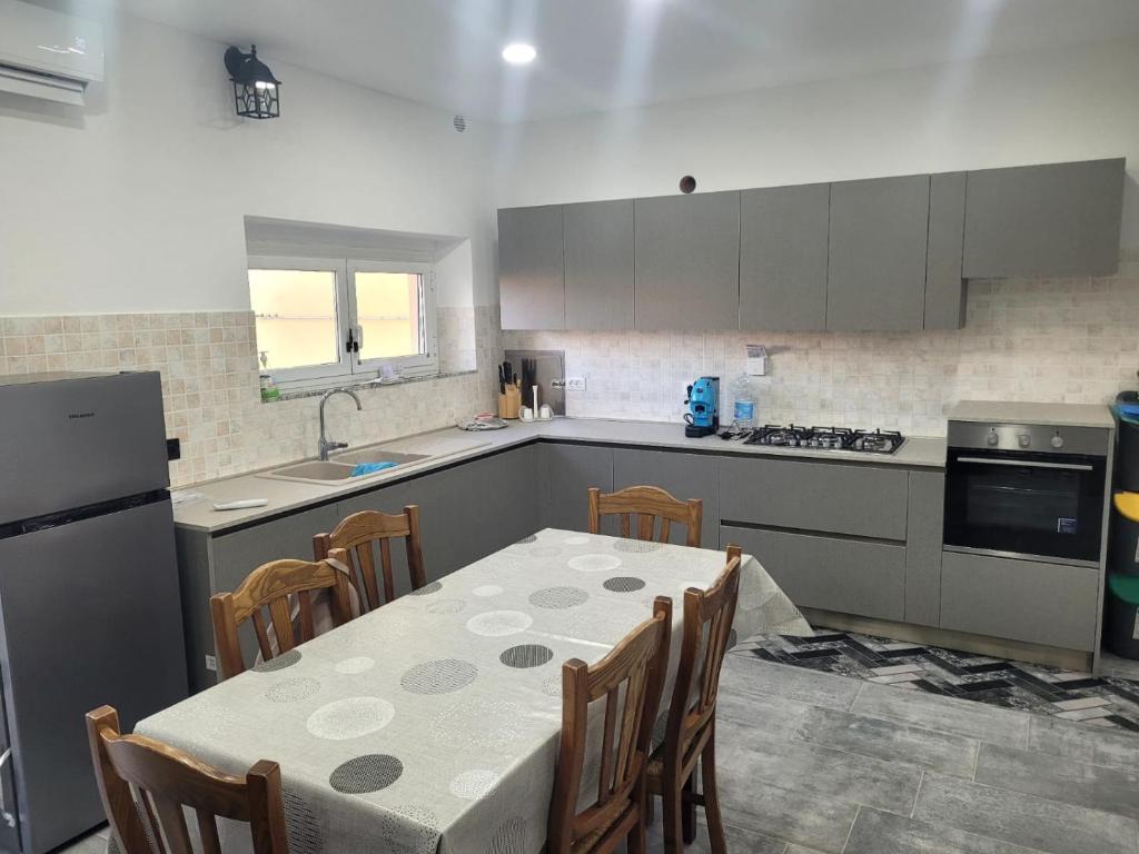 a kitchen with a table and chairs and a kitchen with a refrigerator at Casa Pucci in Venturina Terme