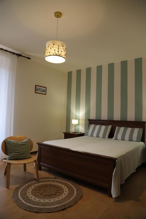 une chambre avec un grand lit et une chaise dans l'établissement La casa di Federica, à Marciana Marina