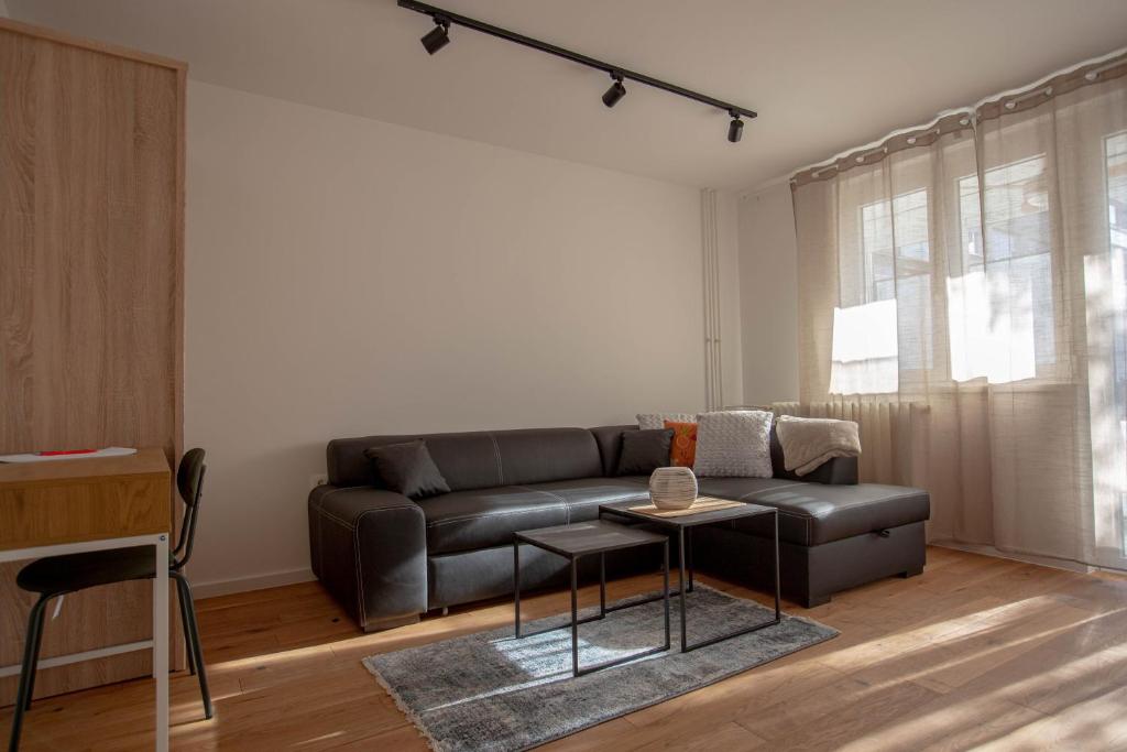 a living room with a leather couch and a table at FIVE apartment - very center in Osijek