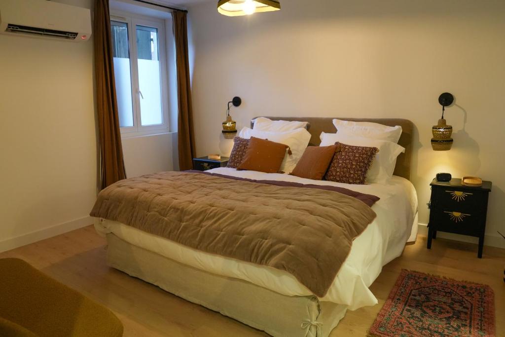 a bedroom with a large bed with pillows and a window at Dijon Hypercentre - Loge de la chouette in Dijon