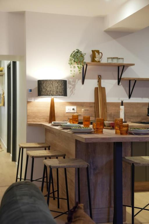 - une cuisine avec un comptoir en bois et des tabourets dans l'établissement Dijon Hypercentre - Loge de la chouette, à Dijon