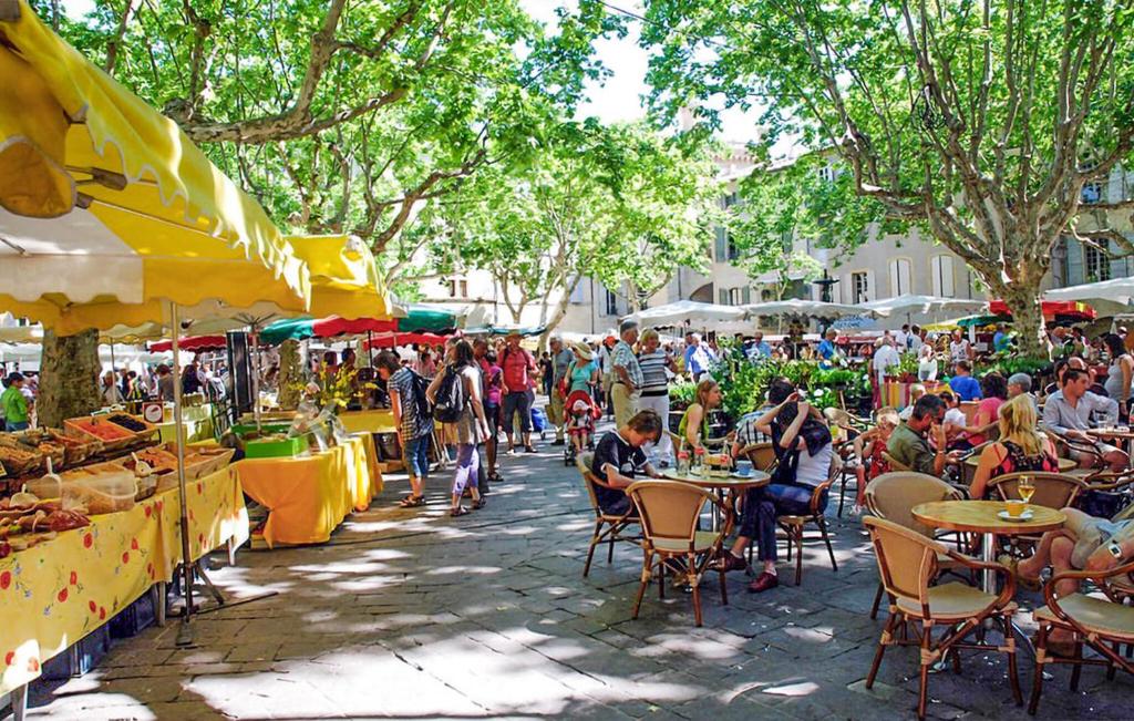 Un groupe de personnes assises à table sur un marché extérieur dans l'établissement 3 Bedroom Cozy Home In Beauvoisin, à Beauvoisin