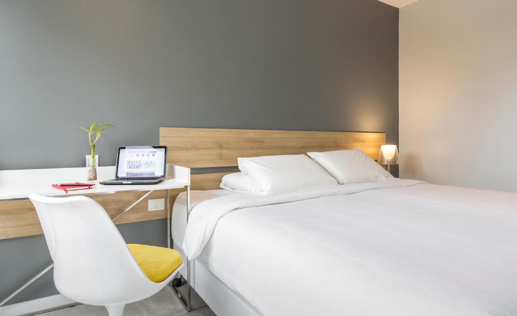 a hotel room with a bed and a desk with a laptop at Hub Hotel Asuncion in Asuncion