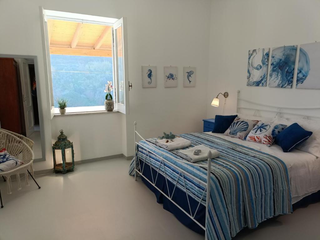 sypialnia z łóżkiem i dużym oknem w obiekcie Casa Eolie relax w mieście Lipari