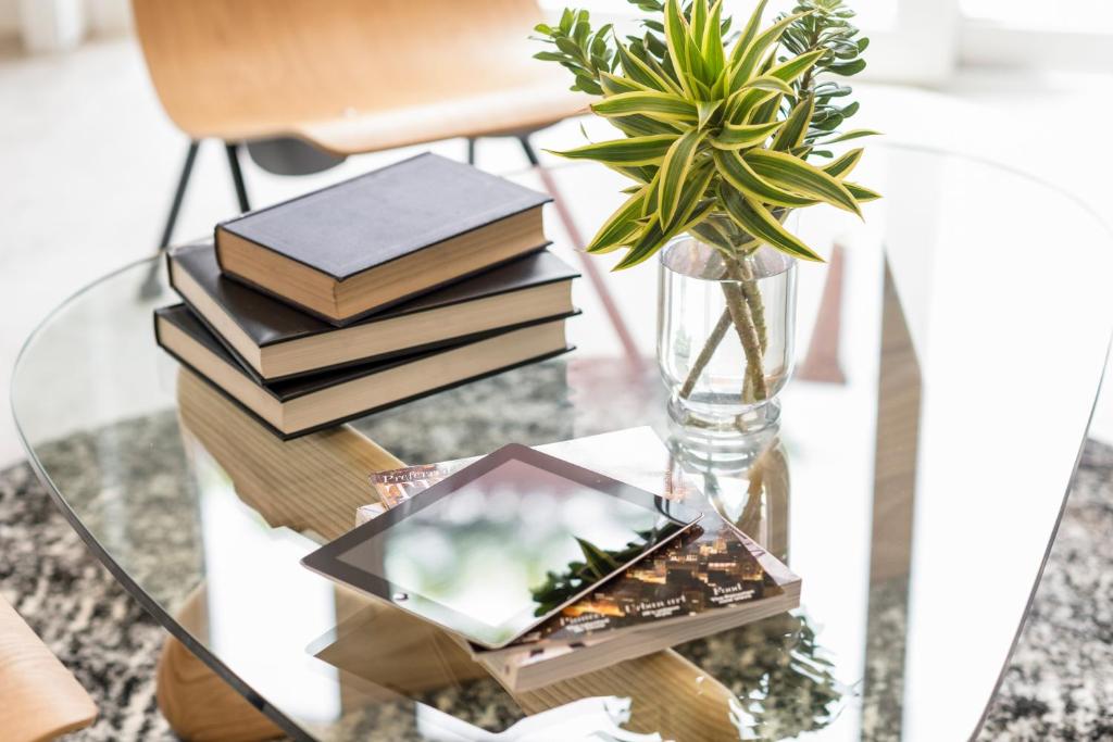 a glass table with books and a vase with a plant at Hub Hotel Asuncion in Asuncion