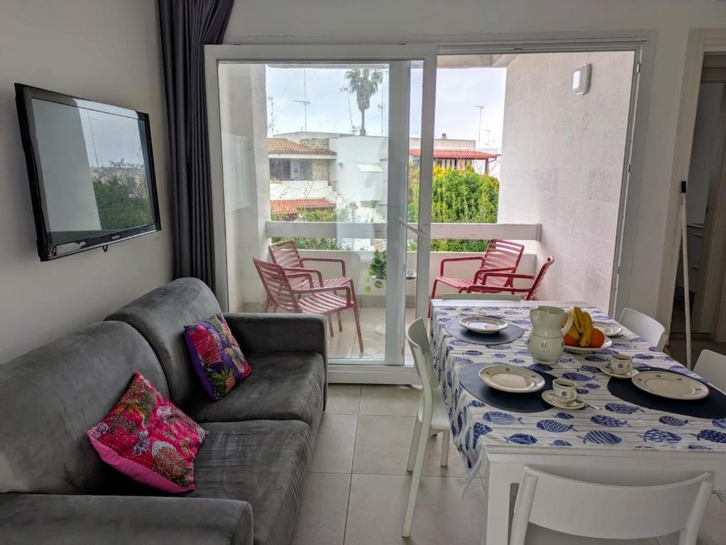 a living room with a couch and a table at Delizioso appartamento vicino al mare di Lecce in San Cataldo