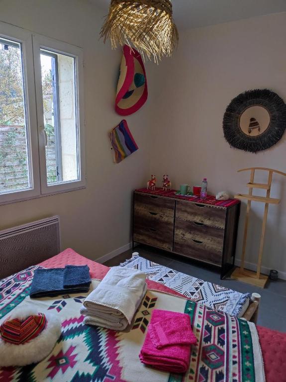 - une chambre avec un lit, des serviettes et une commode dans l'établissement Le Pavillon, à La Celle-sous-Gouzon