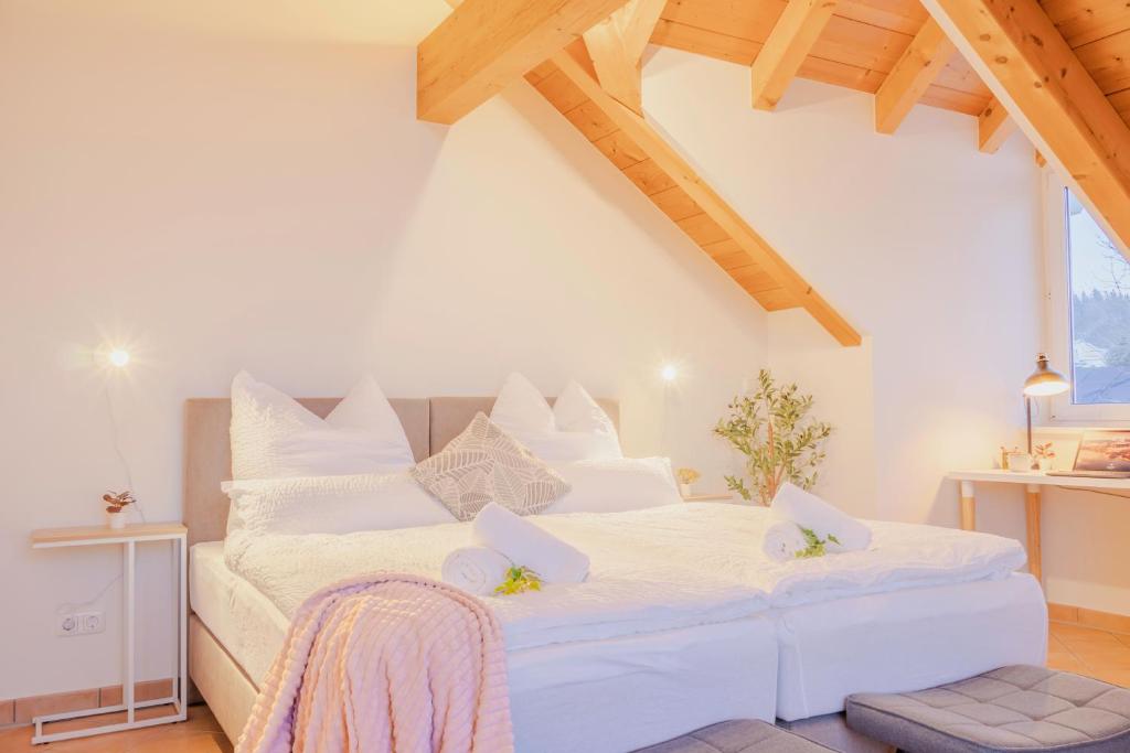 una camera da letto con un grande letto bianco con cuscini bianchi di Helle Wohnung mit Seeblick a Tutzing