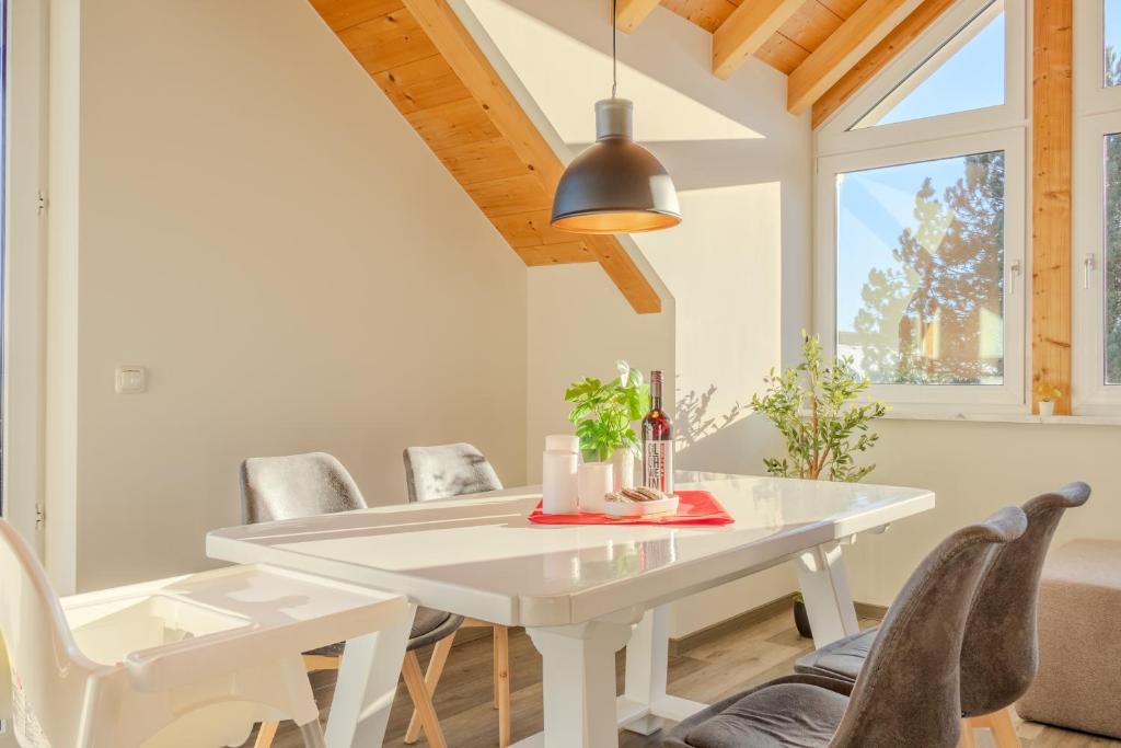 una sala da pranzo bianca con tavolo e sedie bianchi di Helle Wohnung mit Seeblick a Tutzing