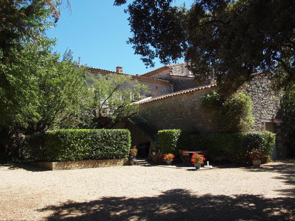un bâtiment avec des haies et un escalier dans une cour dans l'établissement Les MAGNANS, à Gailhan