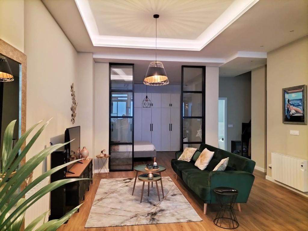 a living room with a green couch and a table at Loft Coruña Mar in A Coruña