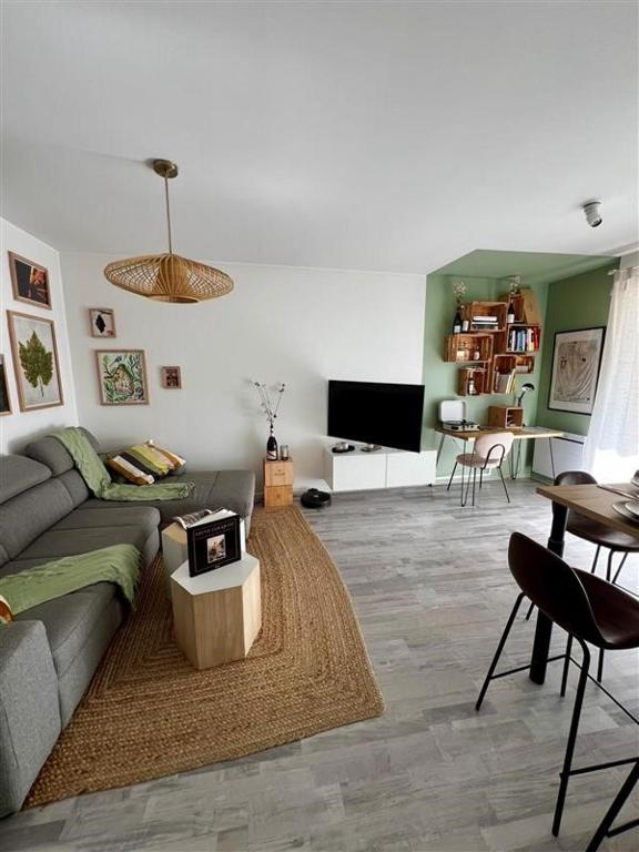 un salon avec un canapé et une table dans l'établissement Clovis - Hypercentre avec balcon et parking, à Reims