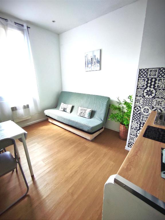 - un salon avec un canapé et du parquet dans l'établissement Le petit oasis dans maison niçoise calme proche mer, à Nice