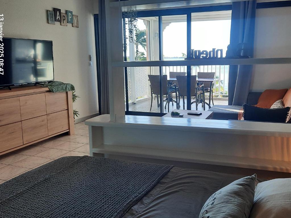 TV a/nebo společenská místnost v ubytování Studio avec piscine et vue lagon