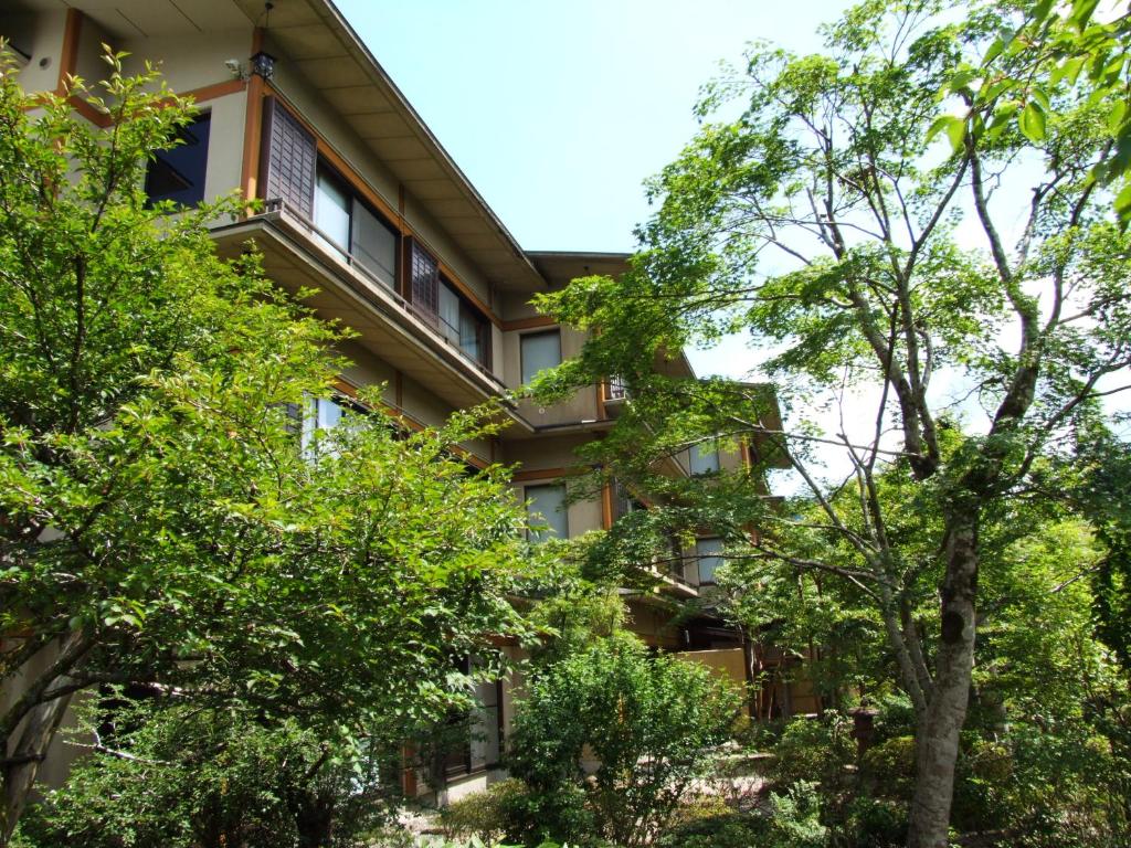 an apartment building with trees in the foreground at Yoshimatsu in Hakone