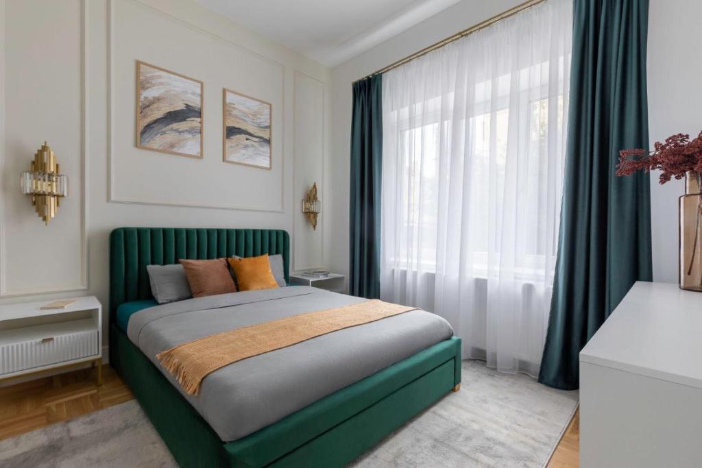 a bedroom with a green bed in front of a window at GOLDENGREEn in Sibiu