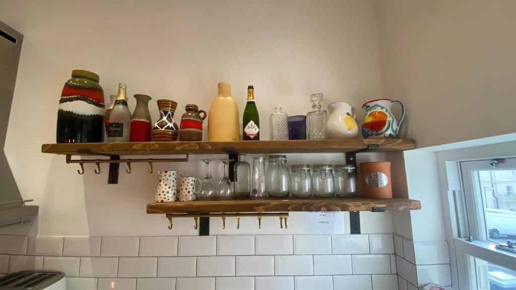 a shelf with bottles and glasses on a wall at Church Retreat - A Magnificent Seaside Apartment-Award Winning in Hastings
