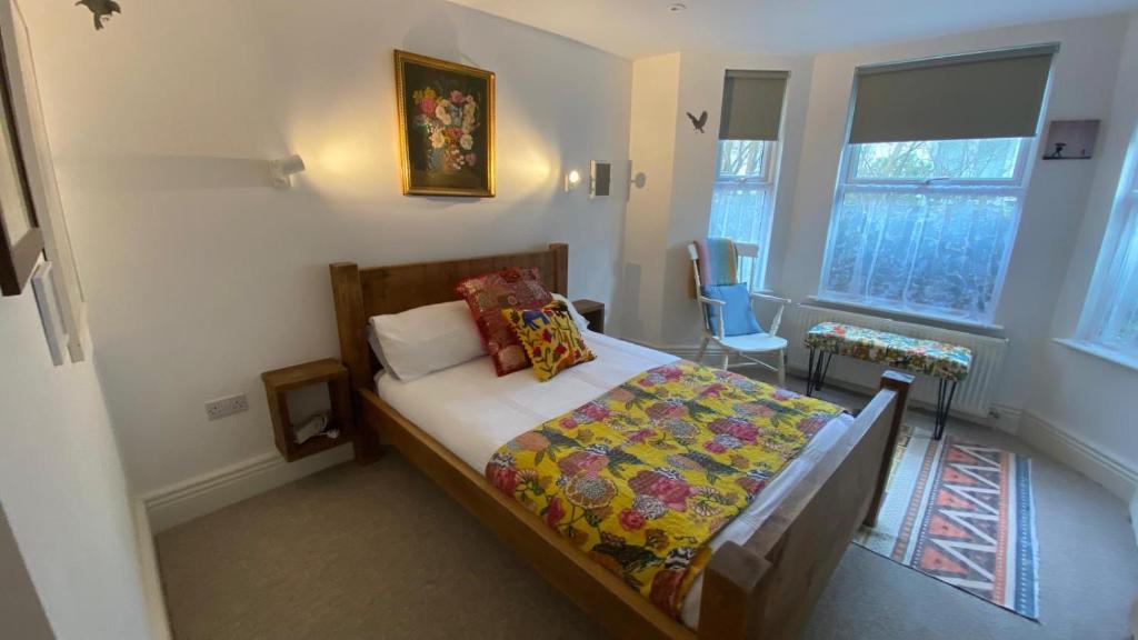 a small bedroom with a bed with a colorful blanket at Church Retreat - A Magnificent Seaside Apartment-Award Winning in Hastings
