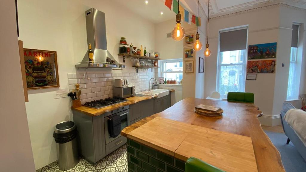 a kitchen with a wooden table and a stove at Church Retreat - A Magnificent Seaside Apartment-Award Winning in Hastings