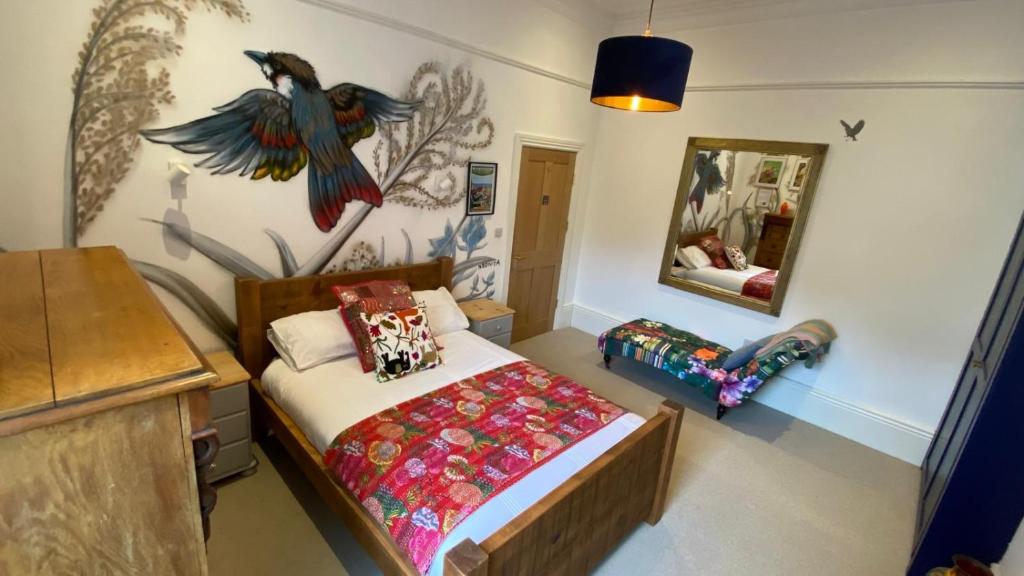 a bedroom with a bed with a bird on the wall at Church Retreat - A Magnificent Seaside Apartment-Award Winning in Hastings