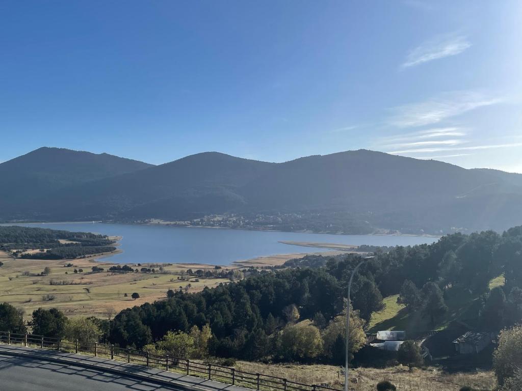 une vue d'un lac avec des montagnes en arrière-plan dans l'établissement Studio Cabine avec WIFI et vue splendide sur le lac et les montagnes, aux Angles