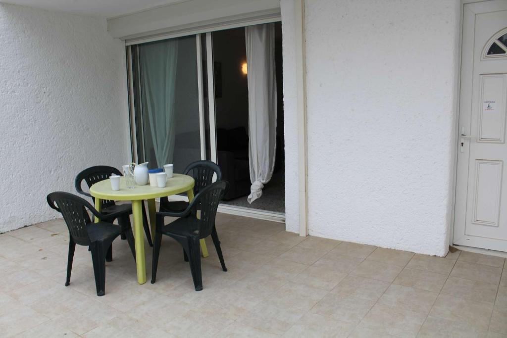 une table jaune et des chaises noires dans une pièce dans l'établissement Maison 3 pièces 6 couchages PORT LA NOUVELLE PN000-127, à Port-la-Nouvelle