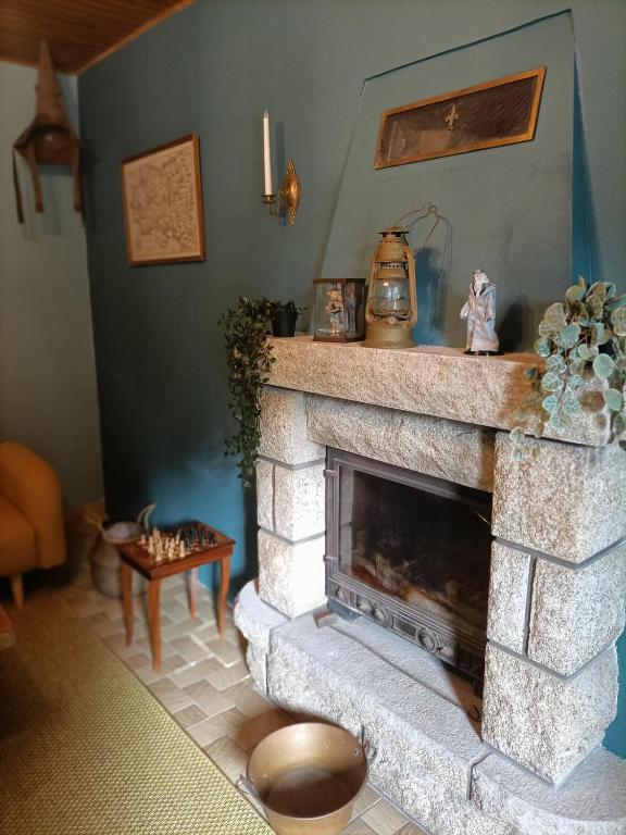 Il comprend un salon doté d'une cheminée en pierre et d'une bouilloire. dans l'établissement Maison de bourg magique de 1860, à Loguivy-Plougras