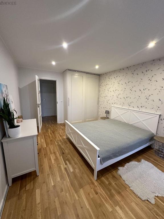 a bedroom with a large bed and a wooden floor at Koreli apartment in Võru