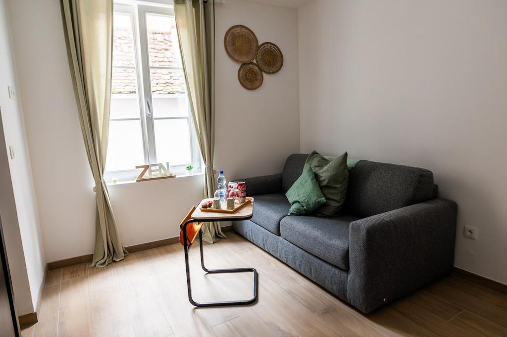 un salon avec un canapé et une table dans l'établissement Au Cocon de J, à Obernai