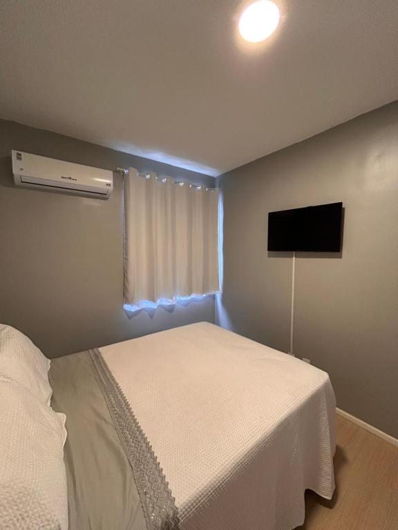 a bedroom with a bed and a flat screen tv at Apartamento Cop 30 in Ananindeua