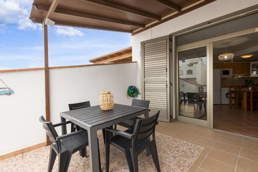 Una mesa de comedor y sillas en el patio de una casa. en 2BR El Cotillo House - Private Terrace, en Cotillo