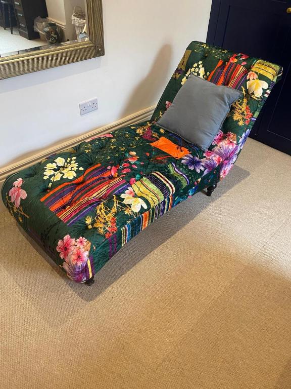 a colorful couch with a pillow on the floor at Church Retreat - A Magnificent Seaside Apartment-Award Winning in Hastings