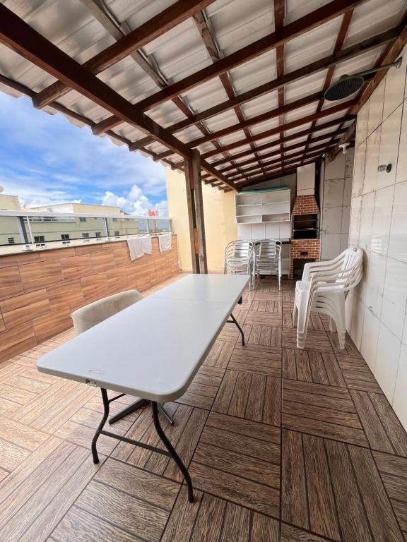 a white table and chairs on a roof at Cobertura Climatizada com Suíte à 2km do Aeroporto de Salvador e Praias in Lauro de Freitas