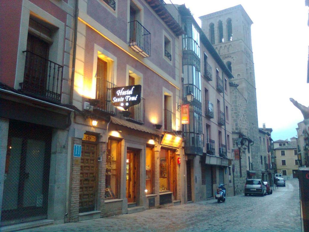 a city street with buildings and a motorcycle parked on the street at Hostal Santo Tomé in Toledo