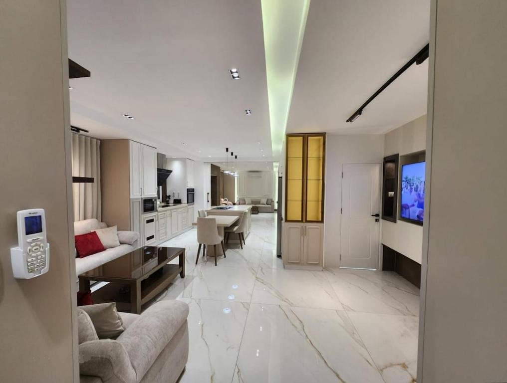 een grote woonkamer met een bank en een keuken bij Halimah 3BR Luxury Apt-Der Ghbar in Amman