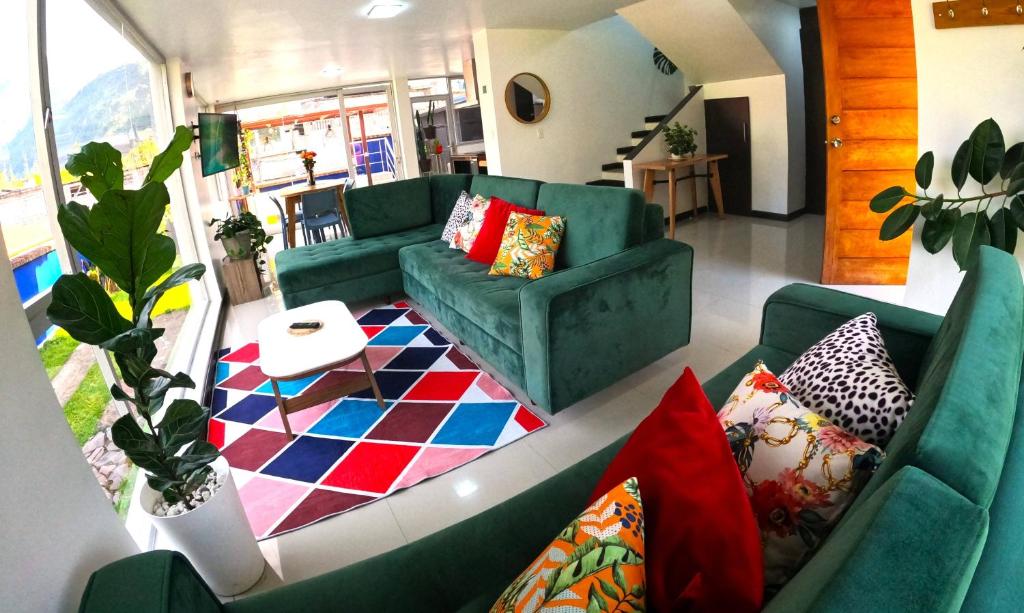 ein Wohnzimmer mit einer grünen Couch und einem Teppich in der Unterkunft CASA VISTA HERMOSA in Baños