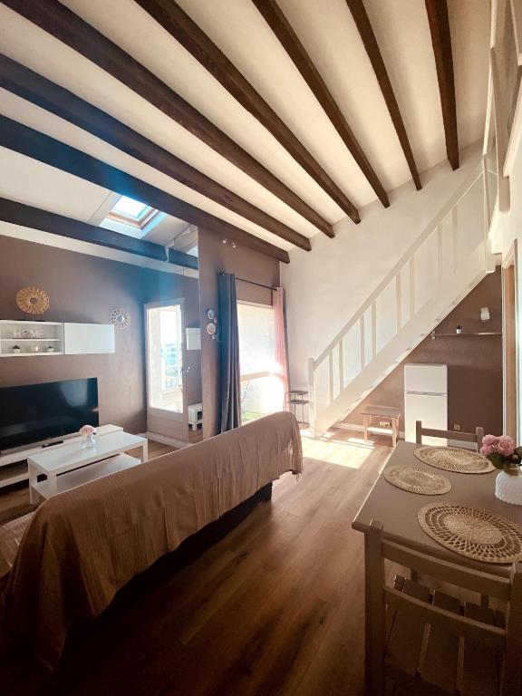 - un grand salon avec un lit et une table dans l'établissement T2 mezzanine avec loggia vue montagne au Port de Saint-Cyprien, à Saint Cyprien Plage