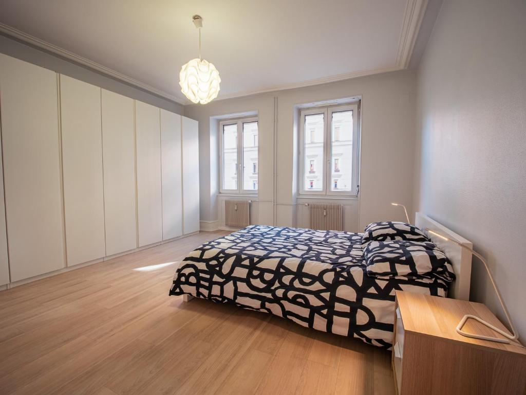 une chambre avec un lit avec une couette noire et blanche dans l'établissement Strasbourg à vos pieds, appartement moderne et lumineux, à Strasbourg