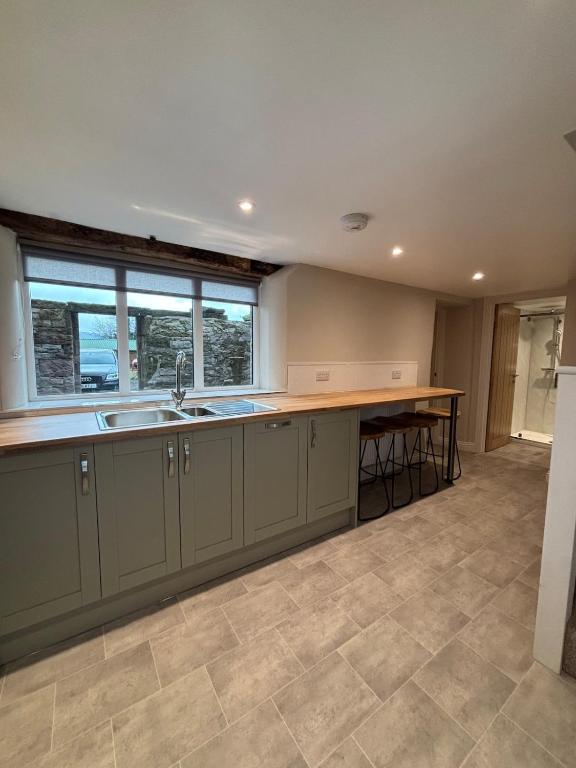 an empty kitchen with a sink and a counter at South View Cottage in Penrith