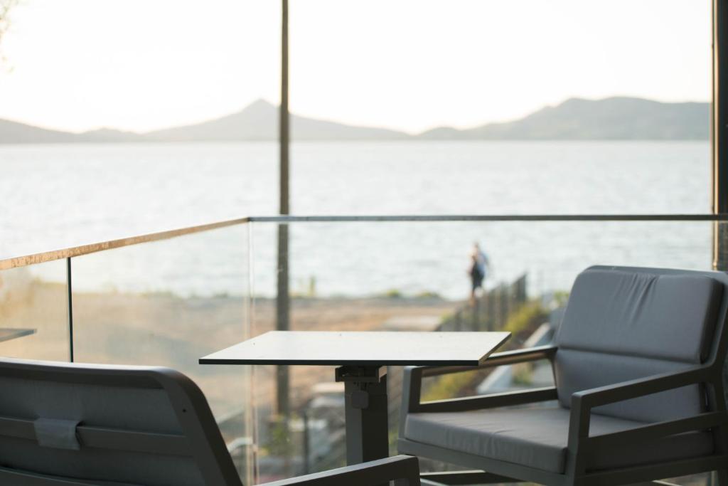 two chairs and a table in front of a window at Sunset Resort 113 in Fonyód