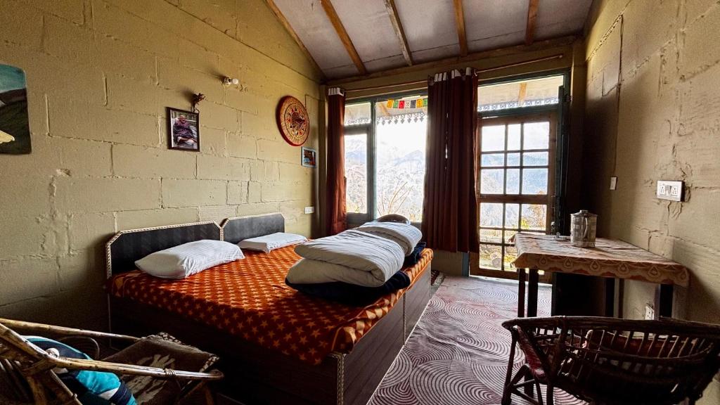 een slaapkamer met een bed met kussens erop bij Basanti Rawat Homestay in Munsyari
