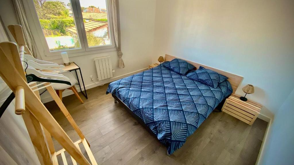 une chambre avec un lit avec une couette bleue dans l'établissement Sewa surf House 10min de Capbreton, à Bénesse-Maremne