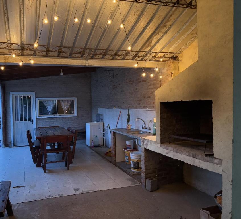 a kitchen and dining room with a large stone fireplace at Apto. en Colonia, a 1 cuadra de la Plaza de Toros in Colonia del Sacramento