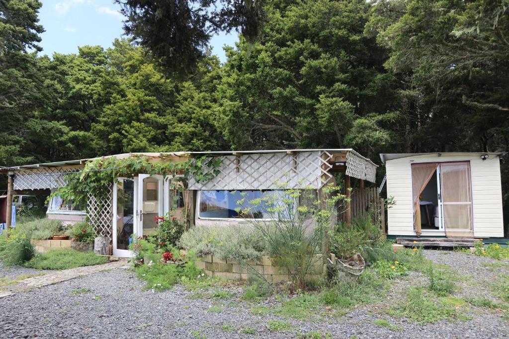 a small house with a lot of plants in the yard at Akerama farm stay in Hukerenui